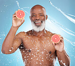 Black man, portrait smile and fruit for skincare nutrition, vitamin C or hydration against a blue studio background. Happy African American male smiling and holding grapefruit for health and wellness