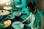 Music, drums and instrument with a man musician in a studio for a recording, performance or practice. Art, band and sound with a young male drummer expressing musical or artistic talent in a studio