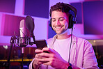 Man, phone and smile in music studio chatting, social media or podcast post at the workplace. Happy male auto tuner smiling on smartphone for networking, sound track or listening in sound proof room