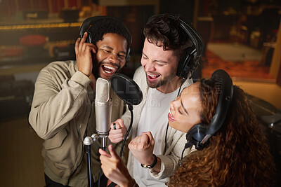 Buy stock photo Music, streaming and diversity, band recording in studio singing into microphone with headphones and talent. Technology, art and creative influencer friends with live stream song for record label.