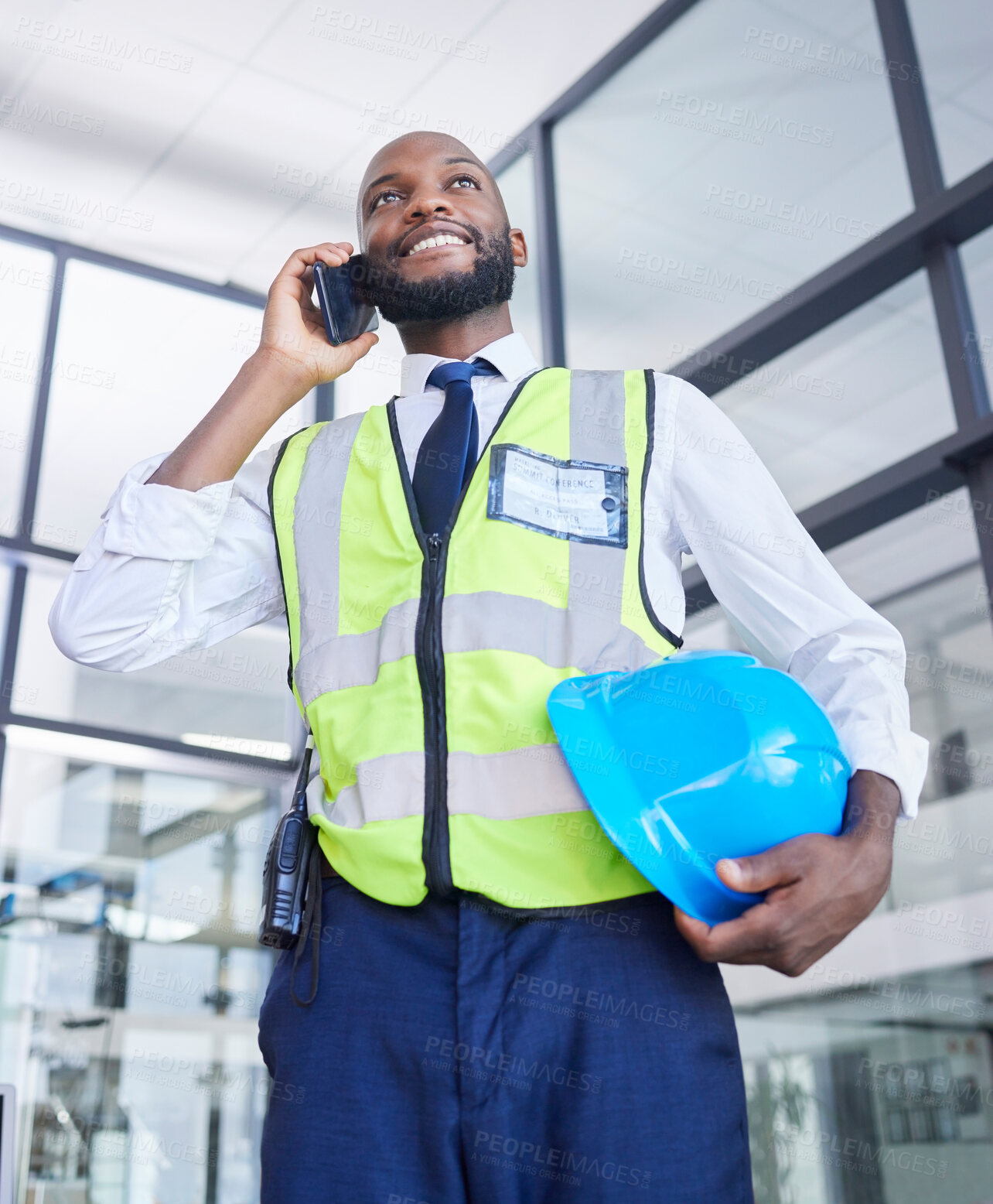 Buy stock photo Black man, construction or phone call in building planning, networking or industrial property renovations in low angle. Smile, happy or building worker with mobile technology, helmet or vision ideas