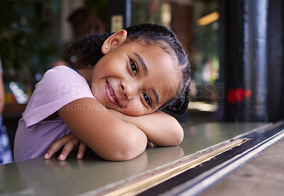 Buy stock photo Portrait, cute and adorable girl at a restaurant, cafe and coffee shop with a smile and happy waiting. Kid, child and young person sitting alone in happiness on a weekend in the city or town 
