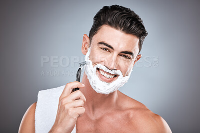 Buy stock photo Razor, face and man with shaving cream in studio isolated on a gray background. Beard, towel and portrait of happy male model with facial product, foam or gel to shave for wellness and hair removal.