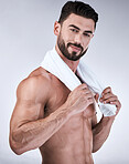 Portrait, fitness or man with towel after shower, cleaning or bathing for hygiene and wellness isolated on a gray background. Topless, body or male fitness model with six pack, abs and biceps muscles