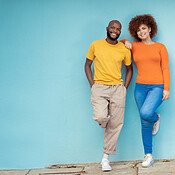 Interracial, portrait and couple on a city wall for travel, holiday and ...