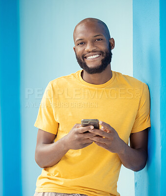 Buy stock photo Black man, portrait or phone typing on blue background, mockup or wall mock up on social media, internet app or blogging. Smile, happy person or fashion clothes on mobile technology for trendy ideas