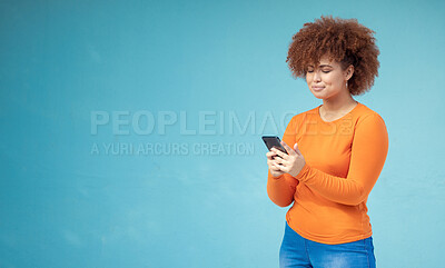 Buy stock photo Woman, cellphone connection and mockup on blue background for social media, website and network. Young female typing on mobile technology in studio for online advertising, marketing app and contact