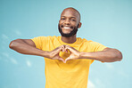 Hand, heart and portrait of man in studio for love, happy and smile against a blue background space. Emoji, hands and face of male model relax with finger, frame and loving message, gesture and sign 