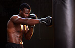 Boxing, fitness and black man with training focus, energy and bodybuilder mindset in dark gym for workout. Challenge, boxer athlete or sports person with strong exercise in mma, martial arts and gear