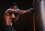 Boxing, fitness and black man isolated on a dark background or gym training and bodybuilder fist impact. Strong, power and focus of boxer, athlete or sports person with exercise, workout in mma gear