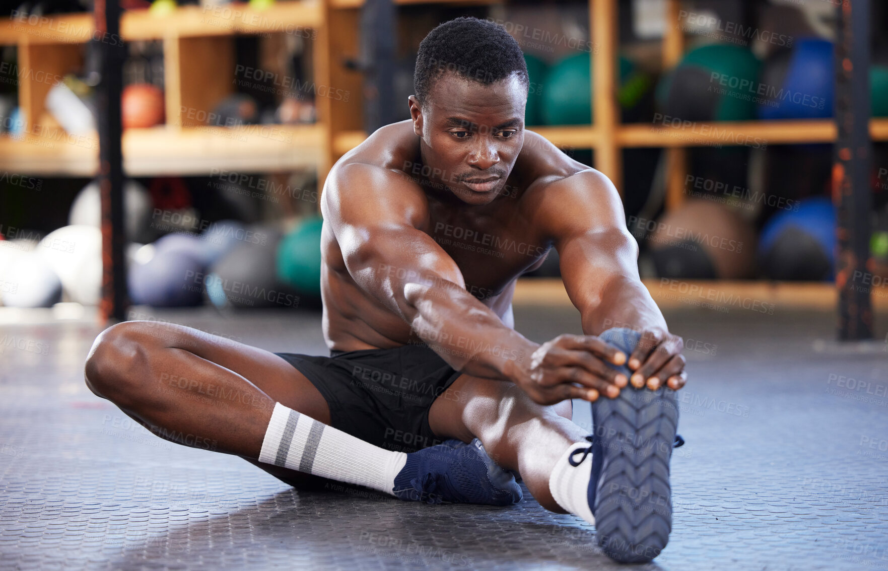 Buy stock photo Stretching. fitness and health with black man in gym for sports, workout and performance. Wellness, exercise and training with athlete and warm up legs on floor for cardio, endurance and energy