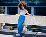 Portrait, fashion and serious with a black woman in the city on a bridge, looking relaxed during summer. Street, style or urban and an attractive young female posing outside with an afro hairstyle