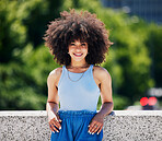 Portrait, fashion and city bridge with a black woman outdoor, looking relaxed during a summer day. Street, style or urban and an attractive young female posing outside with an afro hairstyle