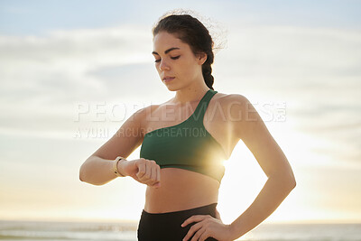Buy stock photo Smart watch, woman and fitness at sunset on beach for exercise workout, training and nature. Stopwatch, sports and female at sea check time, heart rate and monitor healthy body progress for wellness