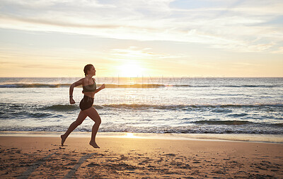 Buy stock photo Woman, fitness and runner on the beach in sunset for healthy cardio exercise, training or workout in the outdoors. Female running or exercising in sunrise for health and wellness by the ocean coast