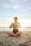 Woman, yoga and meditation on the beach in namaste for spiritual wellness or zen workout in the sunset. Female yogi relaxing and meditating for calm, peaceful mind or awareness by the ocean coast