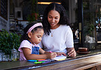 Art, drawing and mother and child at a restaurant with an activity, creativity and color on paper. Creative, happy and girl learning to draw with her mom while eating at a cafe and waiting for food