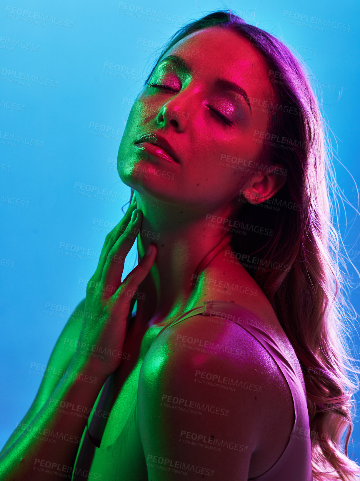 Buy stock photo Woman skincare, glowing or neon lighting on isolated blue background and hands on neck, body or skin. Beauty model, touching or creative fantasy with green, pink lights or makeup cosmetics aesthetic