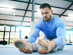 Fitness, exercise or man stretching legs in gym before training, workout or health wellness. Focus, serious gymnastics or sport athlete doing pilates, meditation or zen balance in sports studio floor