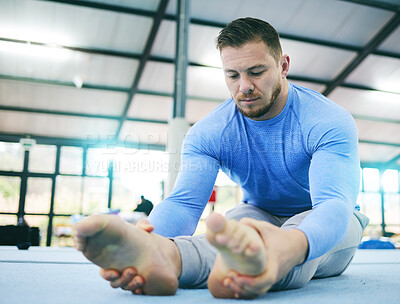 Buy stock photo Gymnastics, exercise or man stretching legs in gym before training, workout or health wellness. Focus, serious fitness or sport athlete doing pilates, meditation or zen balance in sports studio floor