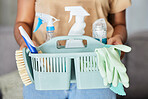 Cleaning, supplies and basket in the hands of a woman housekeeper for domestic hygiene or sanitizing. Covid, service and housekeeping with a female cleaner holding a container of disinfectant