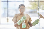 Happy, woman and cleaning window with smile, spray bottle and soap or detergent housekeeping in home or hotel. Housework, smudge and housekeeper or cleaner service washing dirt off glass in apartment