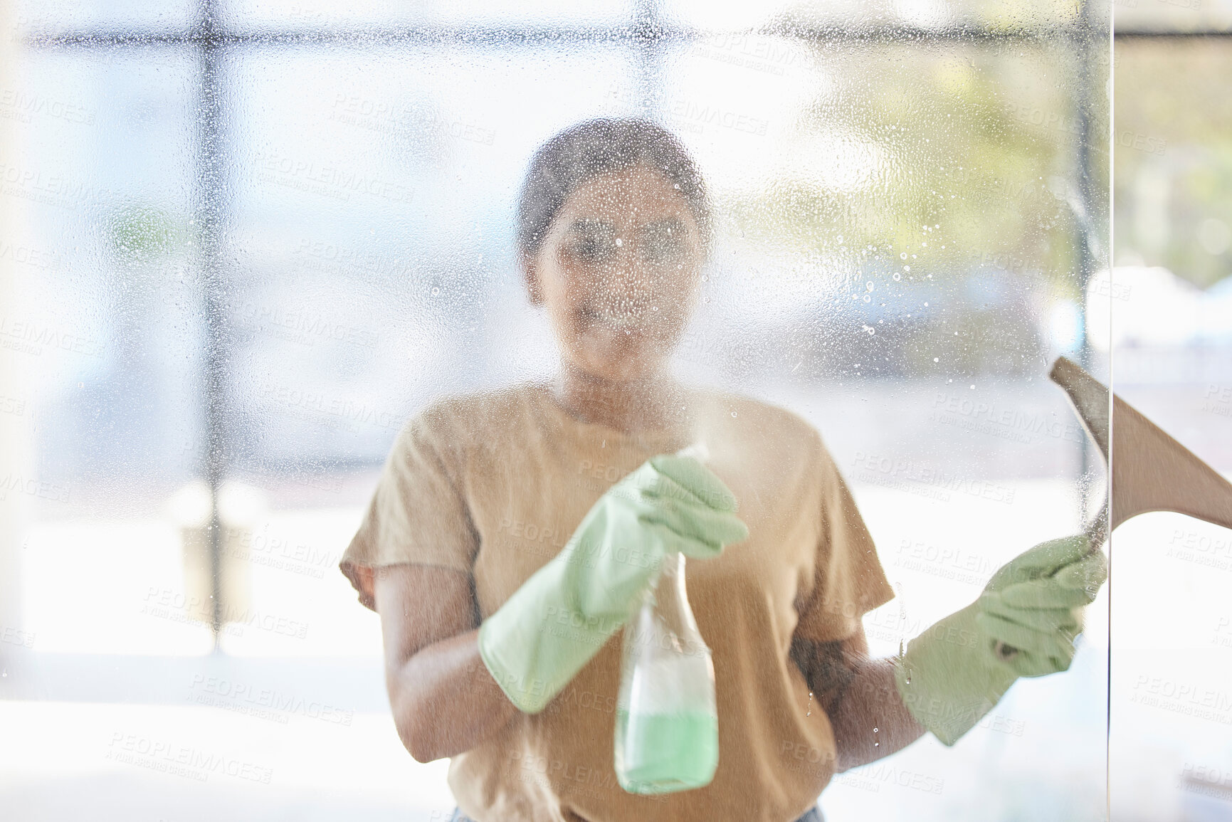 Buy stock photo Happy, woman and cleaning window with smile, spray bottle and soap or detergent housekeeping in home or hotel. Housework, smudge and housekeeper or cleaner service washing dirt off glass in apartment