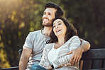 Love, couple and relax on park bench, laughing and having fun together outdoors. Valentines day, romance hug and care of man and woman sitting on romantic date, laugh at funny joke or comic comedy.