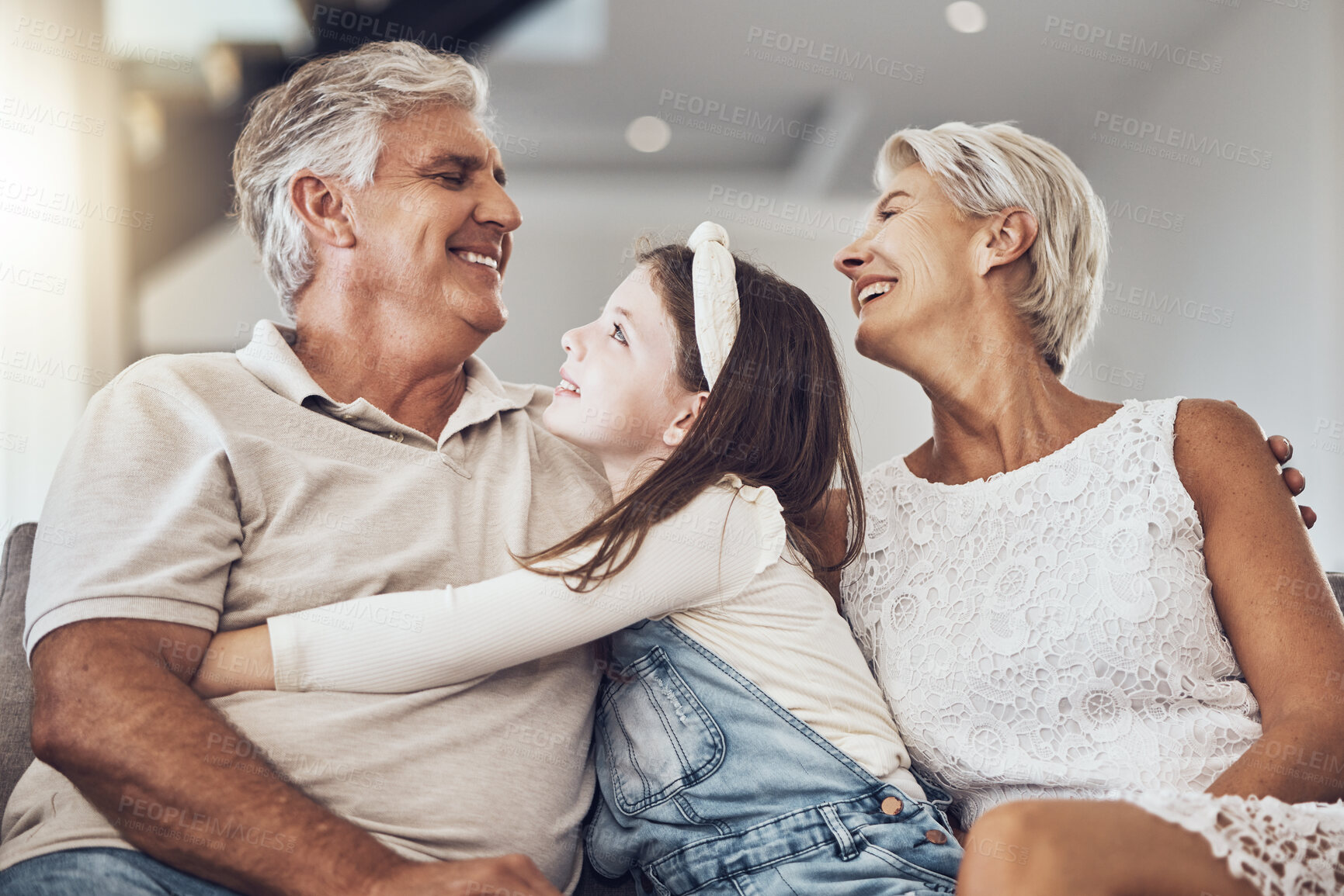 Buy stock photo Relax, love or grandparents hug a girl in living room bonding as a happy family in Australia with care. Retirement, smile or elderly man relaxing old woman with child at home together on fun holiday 