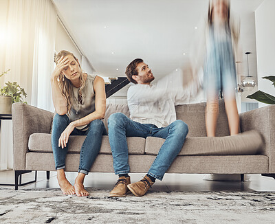 Buy stock photo Family life stress, parents and child, chaos at home and energy, motion blur and burnout headache. Kid jump on couch, woman has migraine and man calming girl, hyperactive with ADHD and mental health 