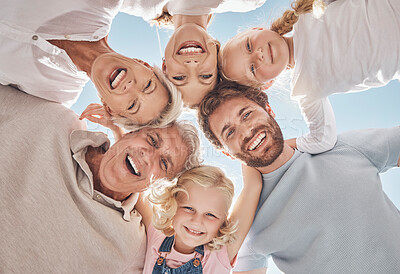 Buy stock photo Happy family, huddle and smile below in trust, community or support together against a blue sky. Portrait of grandparents, parents and children hugging, smiling or bonding for holiday break in nature