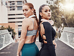 Women, friends portrait and headphones in city for workout, back to back and commitment to self care fitness goal. Woman training group, exercise team and motivation on bridge in metro with support
