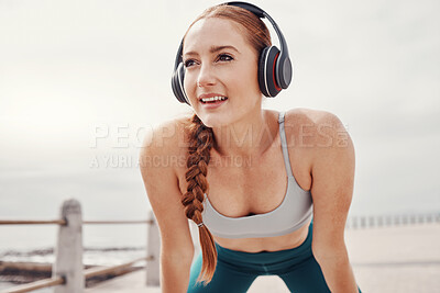 Buy stock photo Running, music and face of woman by ocean with motivation, smile and ready for cardio workout. Fitness, sports and happy girl with headphones in Cape Town for exercise, wellness and marathon training