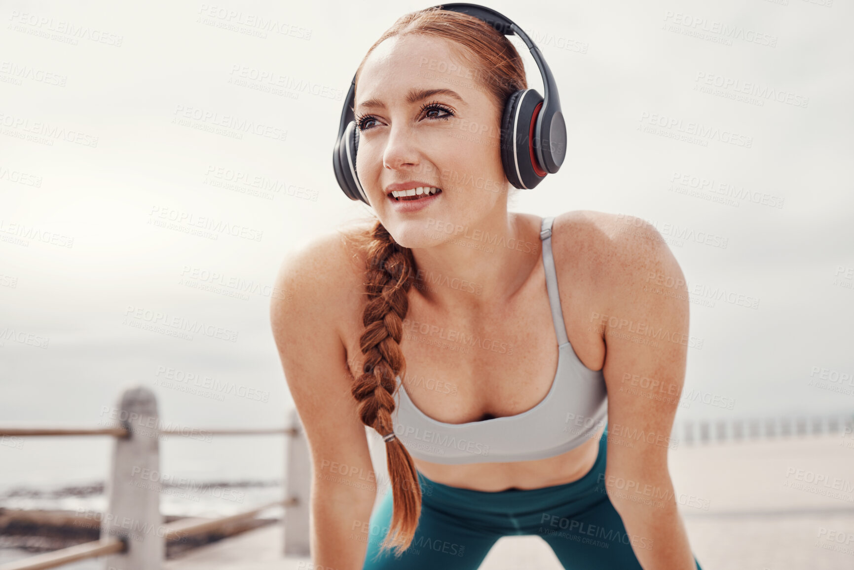 Buy stock photo Running, music and face of woman by ocean with motivation, smile and ready for cardio workout. Fitness, sports and happy girl with headphones in Cape Town for exercise, wellness and marathon training