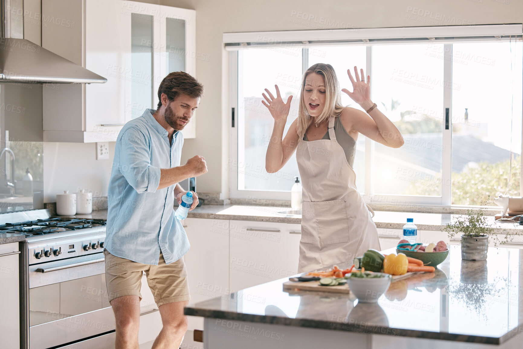 Buy stock photo Happy couple, cooking and dancing together in kitchen, home and comic time with happiness, bonding and love. Man, woman and dance in house with vegetables, food and funny moment with hands in air