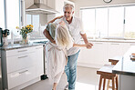 Senior couple dancing, kitchen and happiness with love, care and support in morning at house. Elderly man, old woman and dance together with smile, hands and support in retirement in home with trust