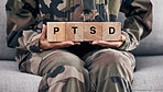 Soldier hands, holding wood block and sofa for therapy, ptsd and help for mental health problem from Ukraine war. Military professional, wooden sign or depression on couch after international combat 