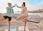 Fitness, beach and women doing a yoga exercise together for mind, body and spiritual wellness. High five, meditation and happy female friends celebrating doing a pilates workout by ocean for health.