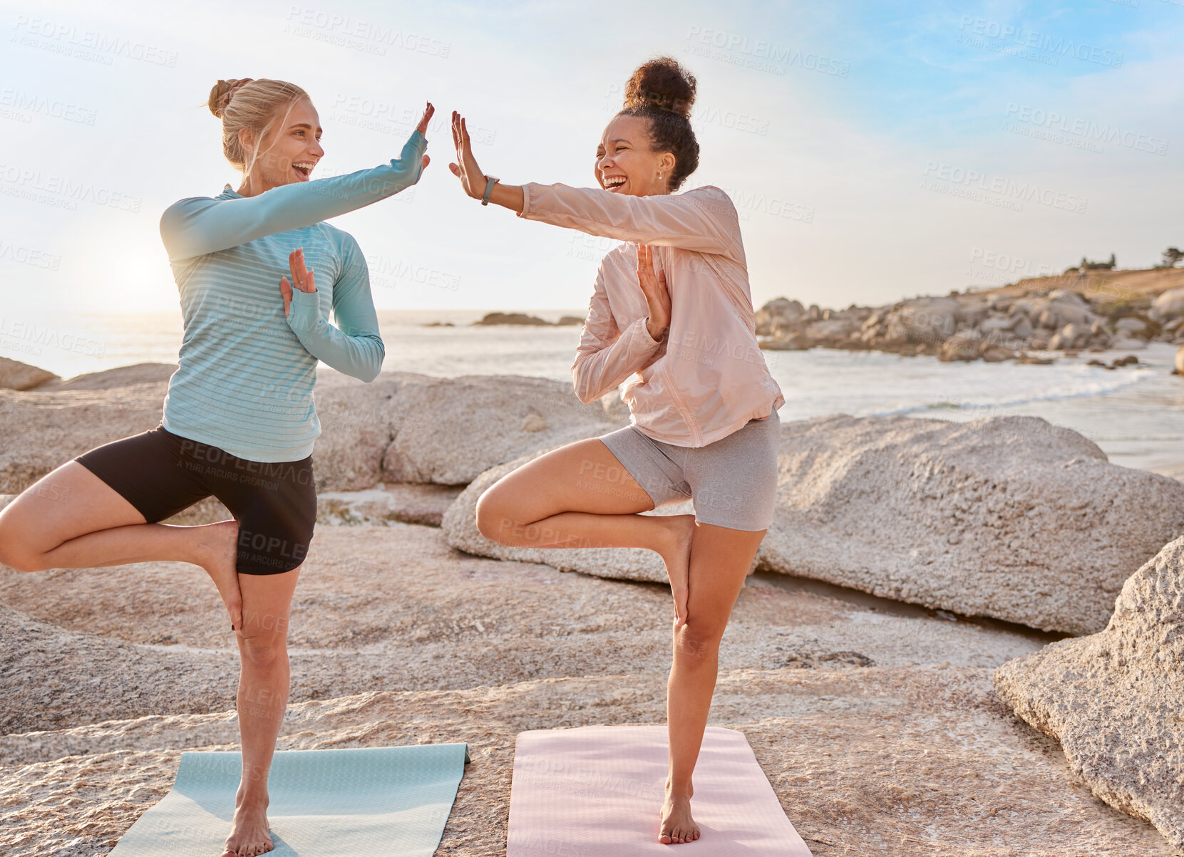 Buy stock photo Fitness, beach and women doing a yoga exercise together for mind, body and spiritual wellness. High five, meditation and happy female friends celebrating doing a pilates workout by ocean for health.