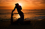 Pilates, yoga and silhouette of woman at sunrise on beach for exercise, training and pilates workout. Motivation, meditation and shadow of girl balance by ocean for sports, wellness and stretching