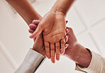 People, hands together and unity below in trust for community, agreement or teamwork at the office. Group piling hand for team collaboration, support or coordination for corporate goals in solidarity