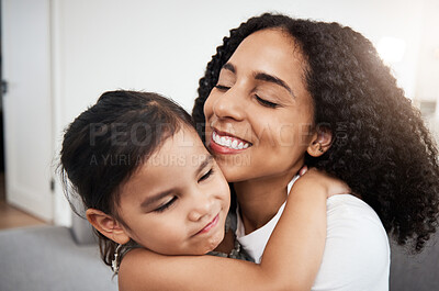 Buy stock photo Hug, love and girl with mother on a sofa, happy and smile while hugging in their home together. Family, embrace and parent with child on a couch, bond and cheerful, loving and caring in a living room