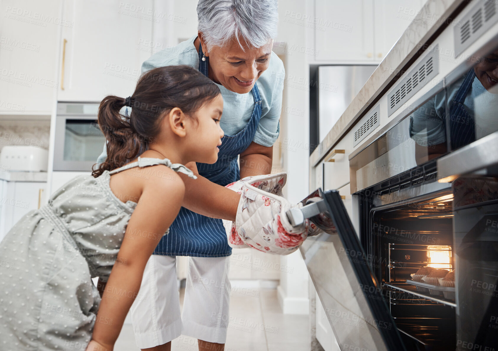 Buy stock photo Cooking, learning and grandmother with girl by oven in kitchen baking delicious muffins. Education, development and happy grandma teaching kid how to bake, bonding and enjoying quality time together.