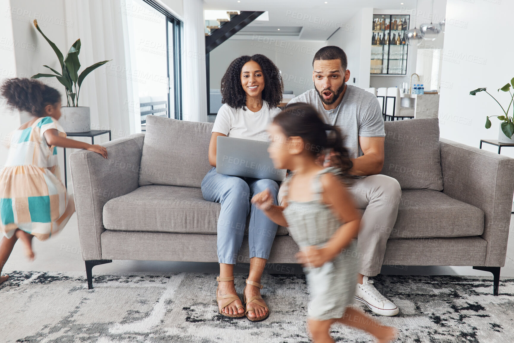 Buy stock photo Black family home, children and running in living room for game, bonding or funny time with parents on sofa. Kids, mother and father on lounge couch with laptop, smile and happiness for love together