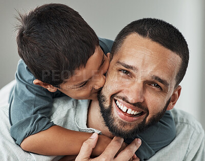 Buy stock photo Love, portrait and kid kissing his father while embracing and relaxing in the living room at family home. Happiness, smile and young man hugging and bonding with boy child with care and in house.