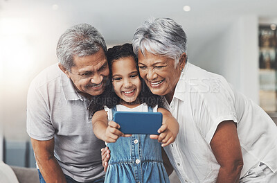 Buy stock photo Love, happy and girl taking selfie with her grandparents in the lounge of modern family home. Happiness, smile and excited child taking picture with grandmother and grandfather at a house in Mexico.