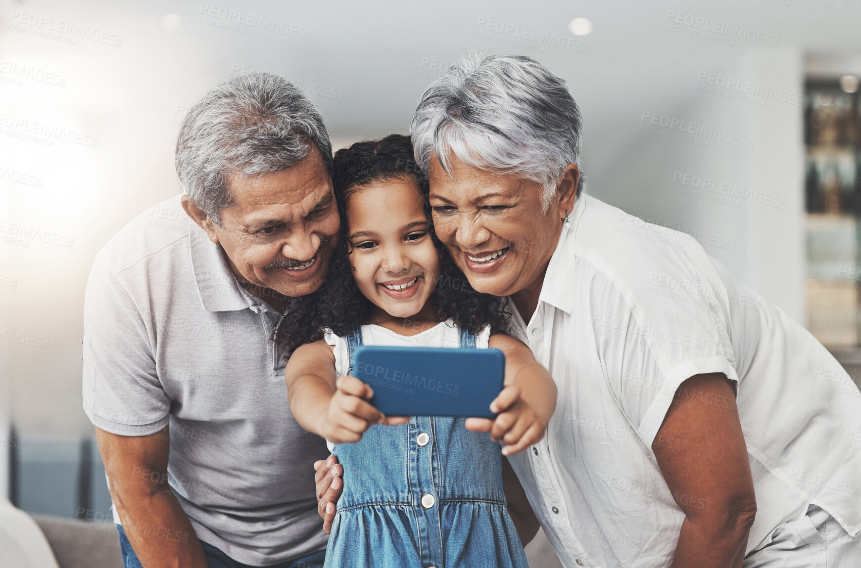 Buy stock photo Love, happy and girl taking selfie with her grandparents in the lounge of modern family home. Happiness, smile and excited child taking picture with grandmother and grandfather at a house in Mexico.