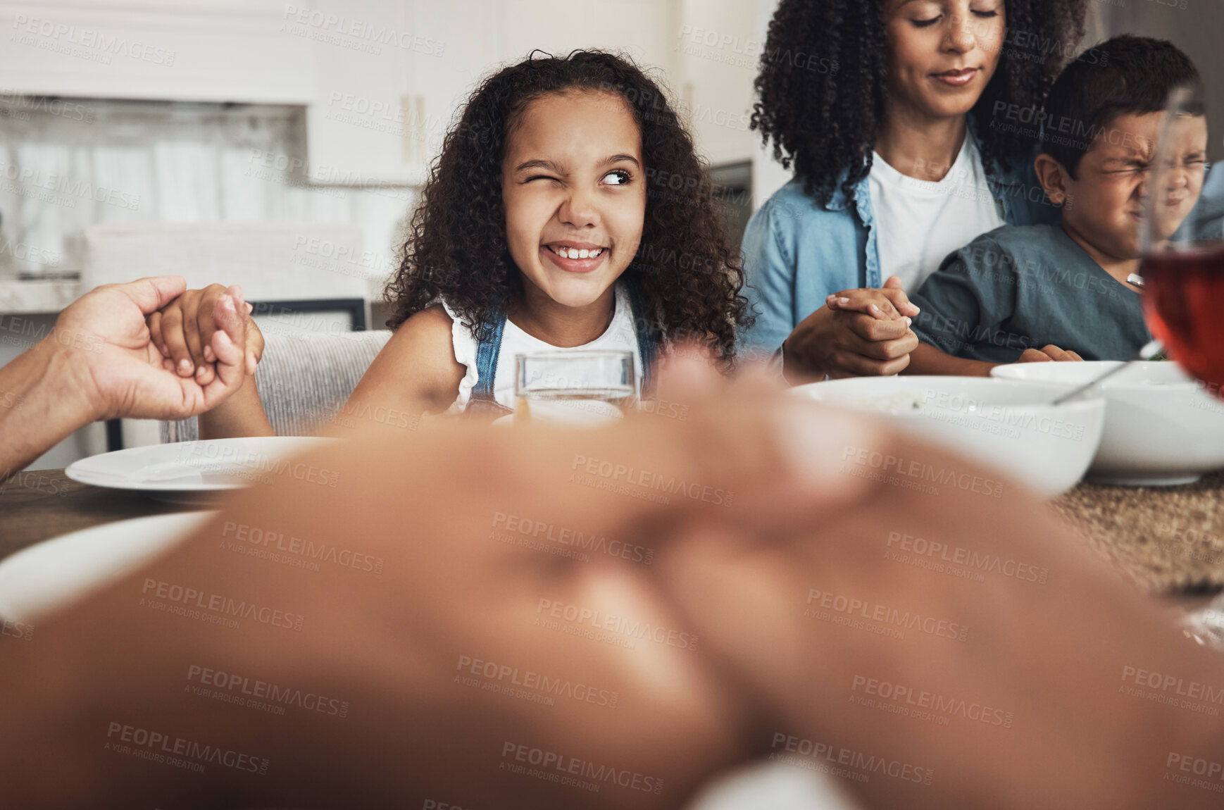 Buy stock photo Happy girl praying with her family for dinner at their home for religion, respect or compassion. Spiritual, gratitude and young child peeping while in a prayer at event, party or supper at her house.