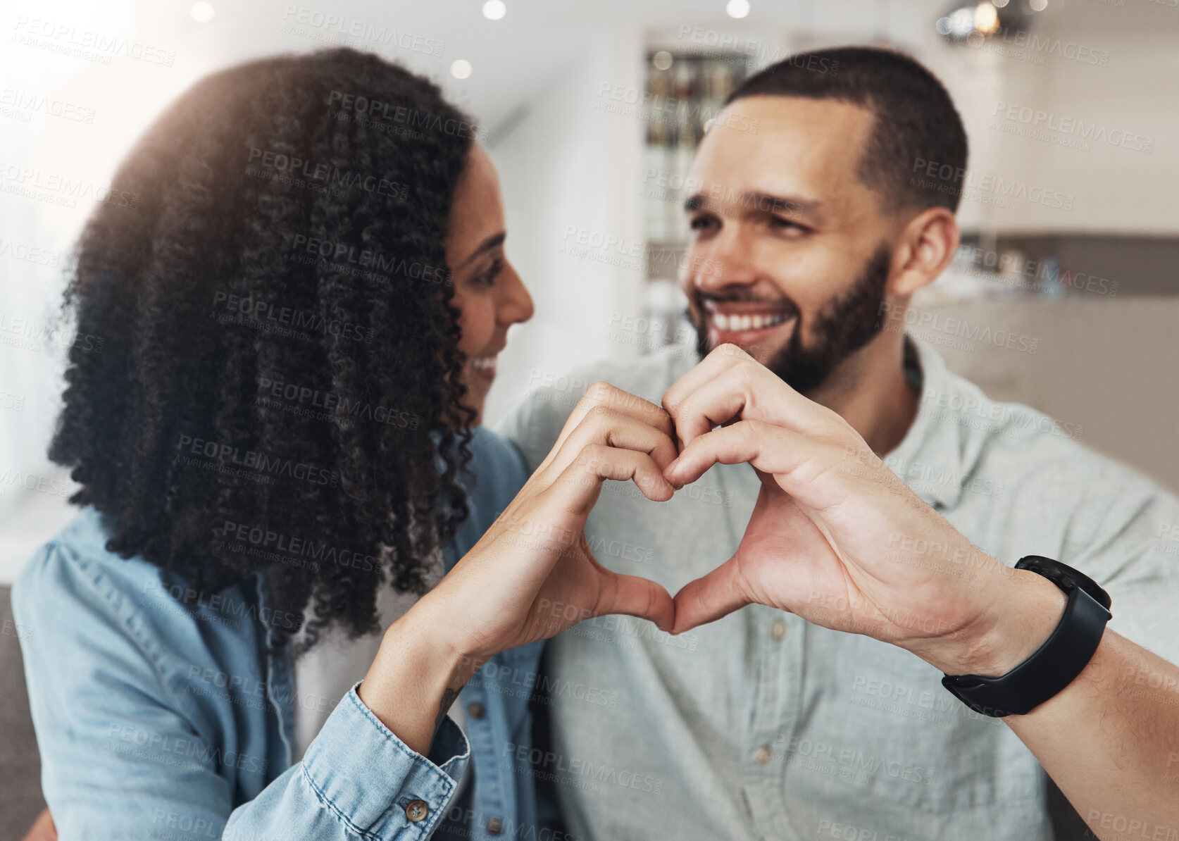 Buy stock photo Love, heart hand sign and happy couple enjoy quality time together, bonding and relax on home living room sofa. Eye contact, emoji gesture and marriage people, man or woman smile in good health