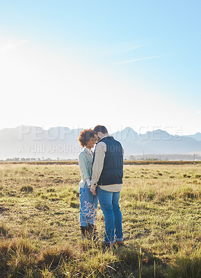 Buy stock photo Love, interracial and couple on countryside vacation, holding hands and joyful outside with romantic view. Romance, happy man and black woman on field, holiday and weekend break, happiness or support